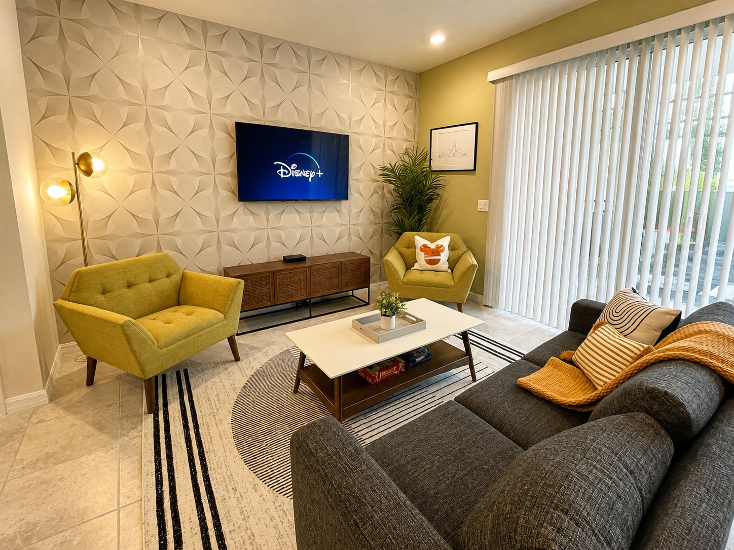 Lounge with textured feature wall, mid-century armchairs and mounted TV