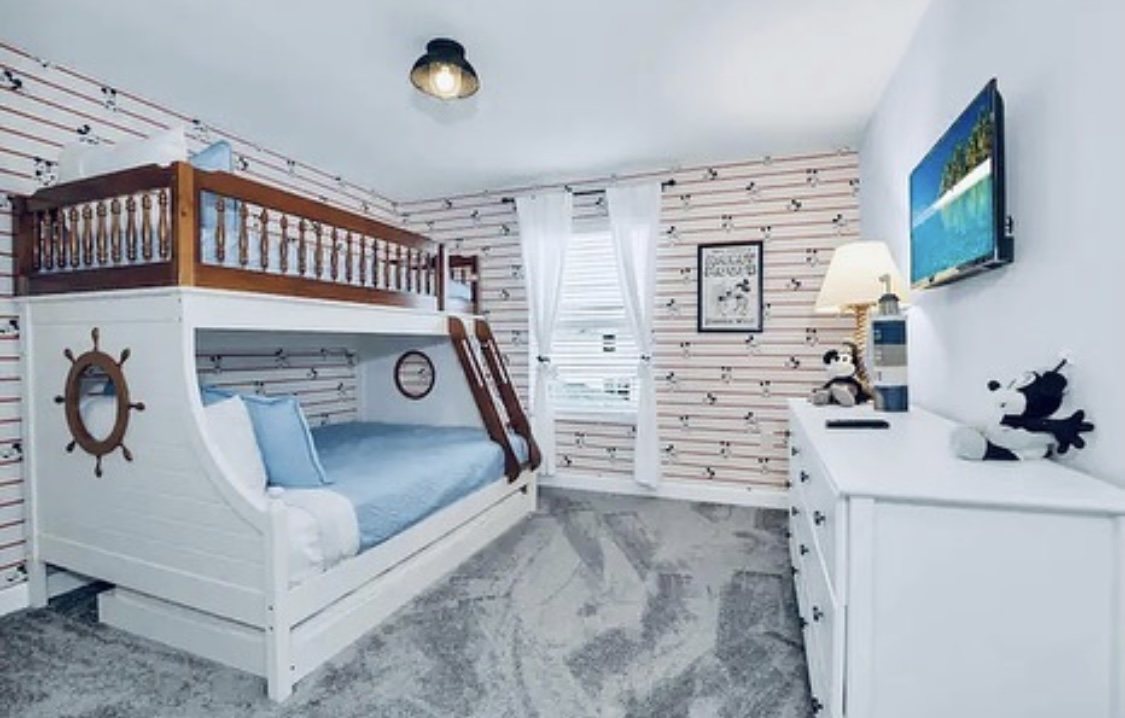 Boat-shaped bunk bed room with striped wallpaper and porthole detailing