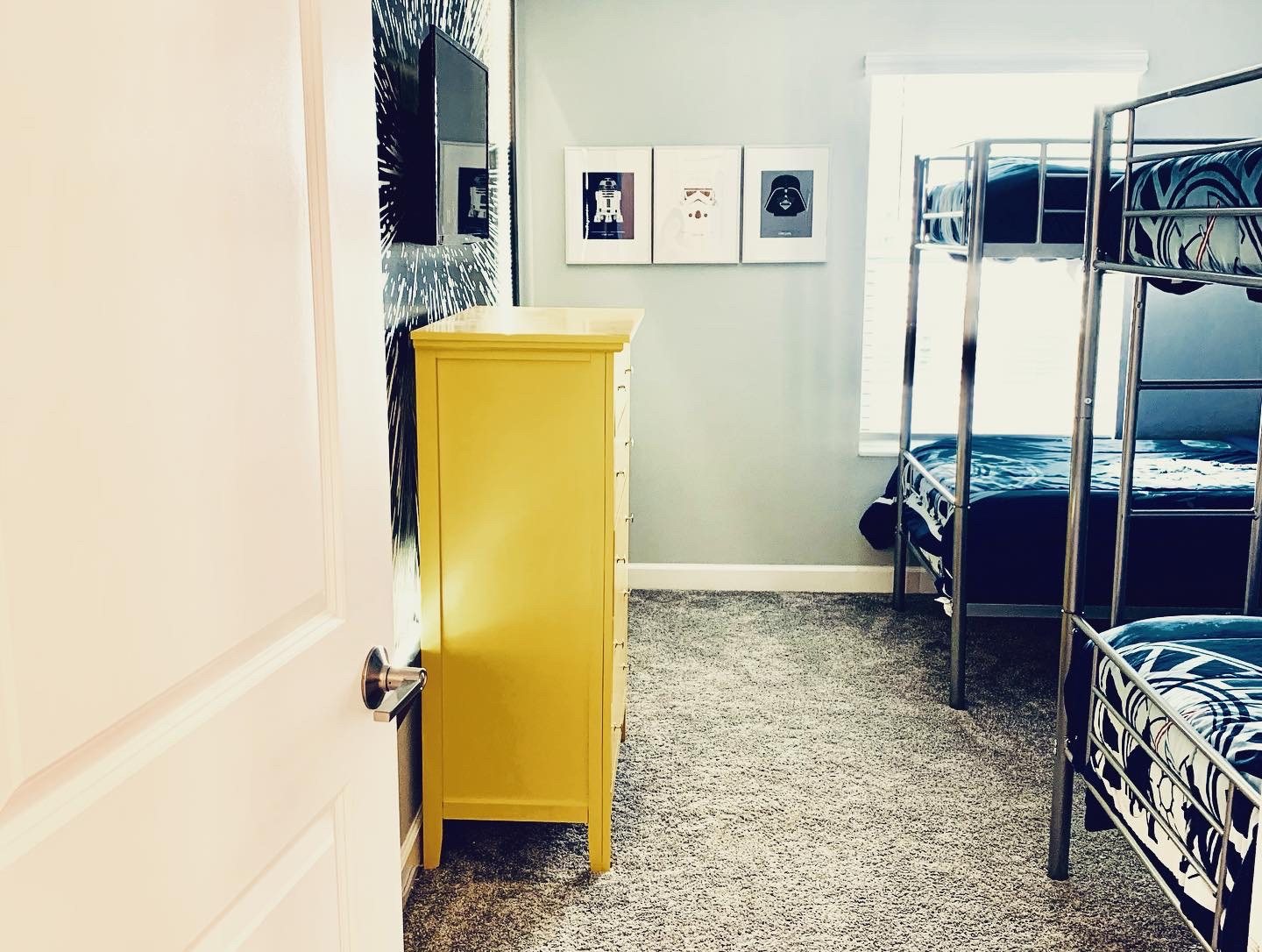 Bunk room showing twin bunks, framed print trio and yellow dresser