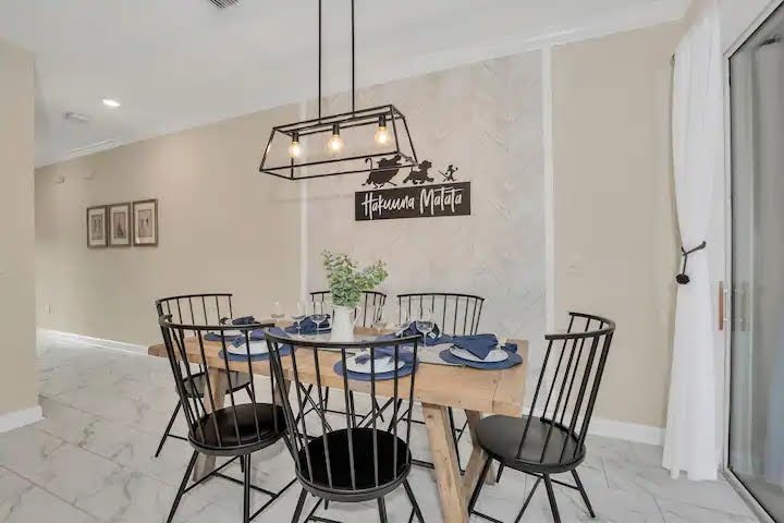 Dining room with timber table, black spindle chairs and feature wall