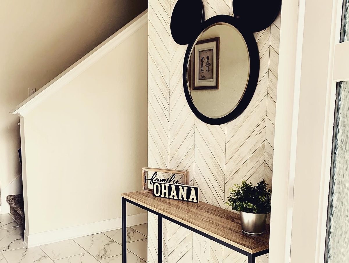 Entryway with herringbone feature wall, console table and round mirror