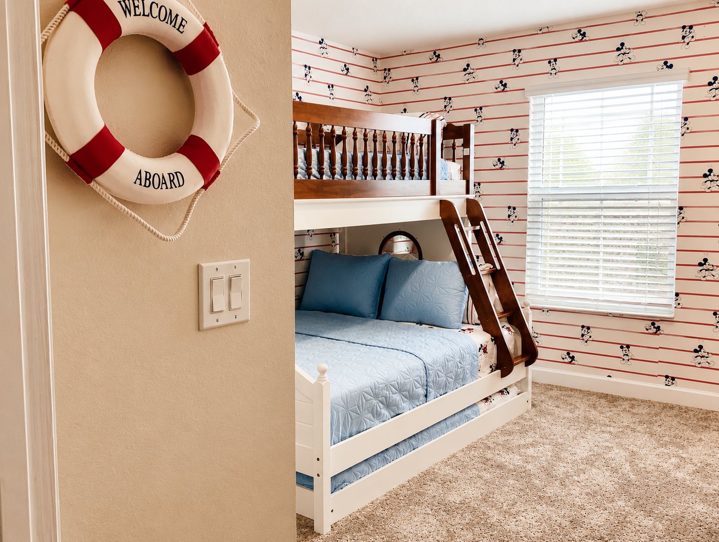 Boat bunk bed room from the doorway with life ring and striped wallpaper
