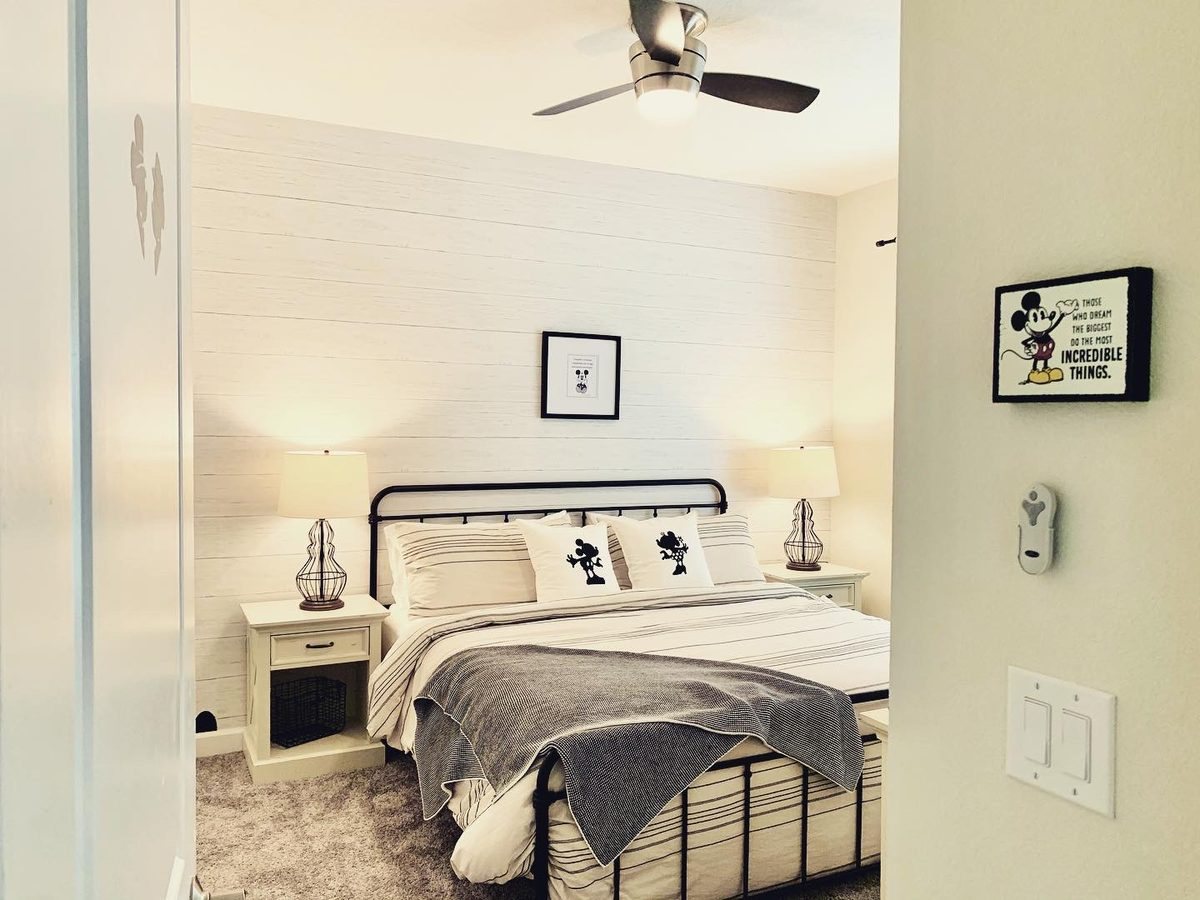 Main bedroom with shiplap feature wall and black iron bed frame